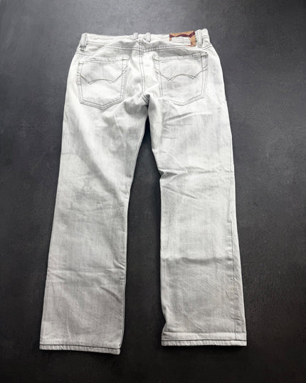 Cult of Individuality grey denim back view showing arched pocket stitching, tan patch and faded crease marks