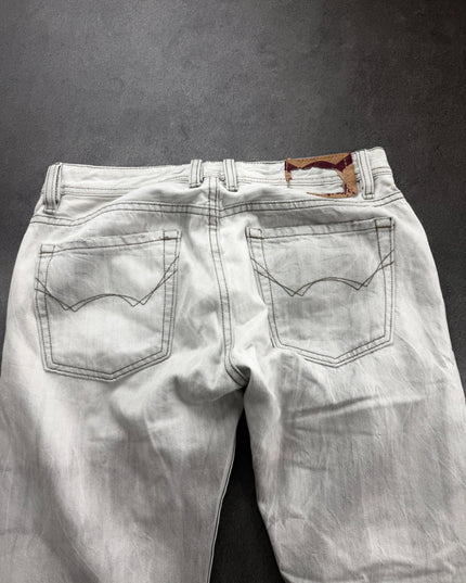 Cult of Individuality denim back close-up showing both pockets, belt loops and tan patch with burgundy print