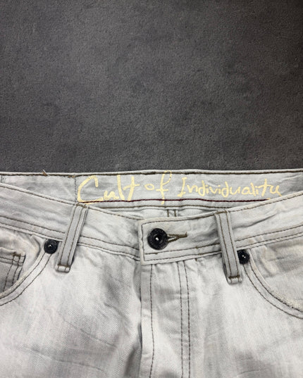 Cult of Individuality denim inner waistband with gold script lettering, button closure and dark rivets close-up