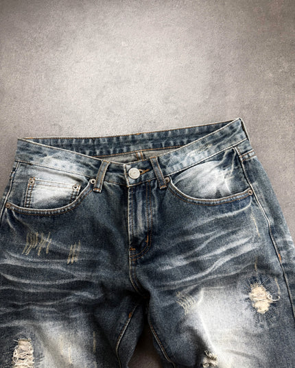 HEISEI denim front waist close-up with button fly, whiskering and shredded thigh patch