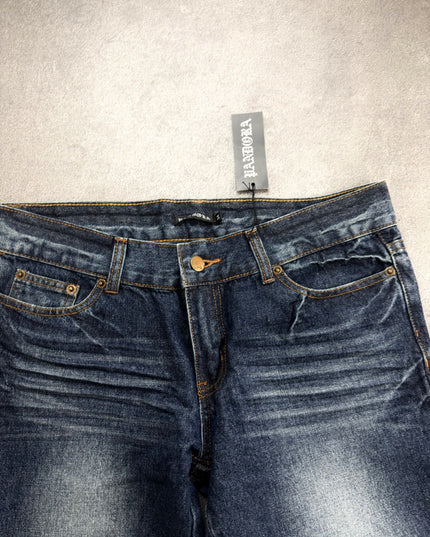 PANDORA denim front waist close-up with hang tag, copper rivets and orange contrast stitching