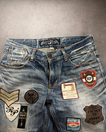 Red Pepper denim front waist close-up with chevron, skull and shield patches