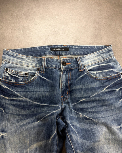 ROOT THREE denim close-up of waistband, button, orange stitching and faded front pockets