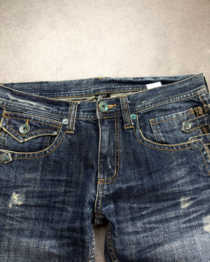 RUSS K denim front waist close-up showing teal buttons, flap pocket and side zip details