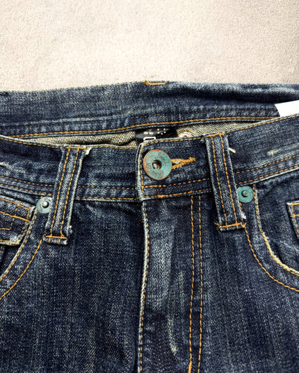 RUSS K bootcut denim leg opening close-up showing lightly frayed hem and amber stitching